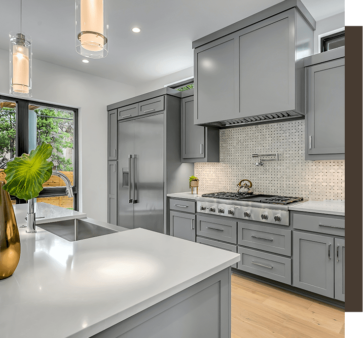 A kitchen with grey cabinets and white counters.