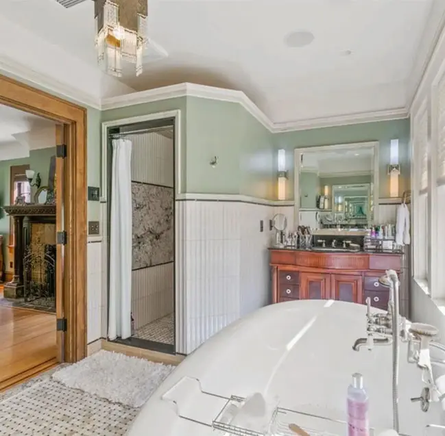 A bathroom with a tub, sink and mirror.