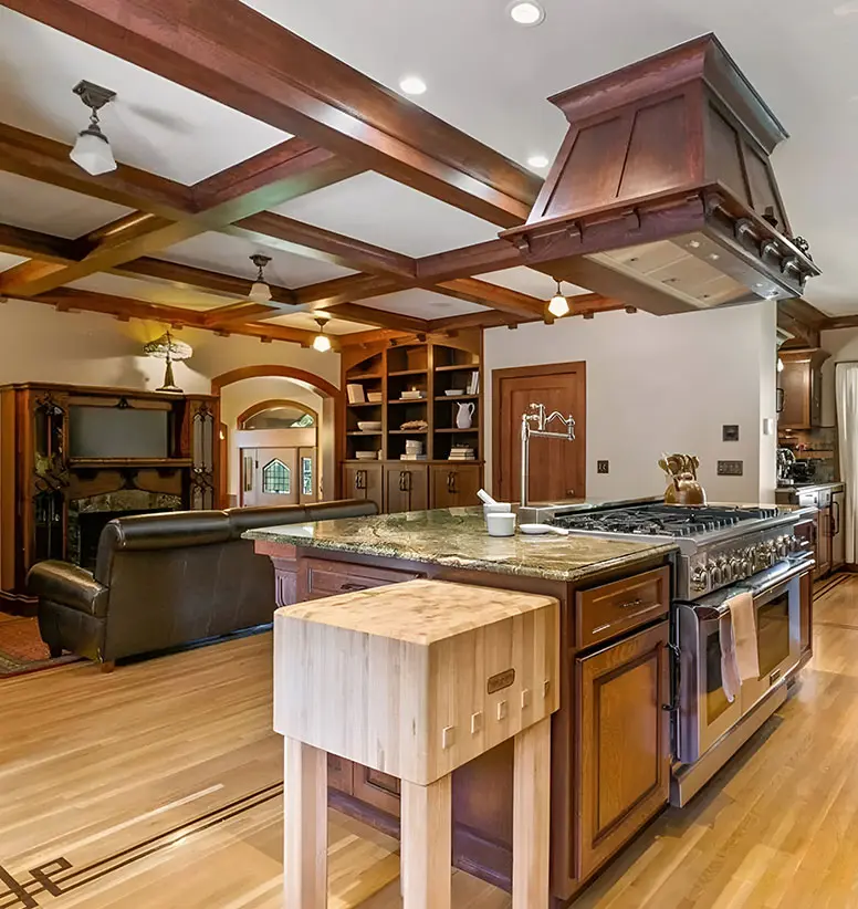 A kitchen with wooden floors and wood cabinets.