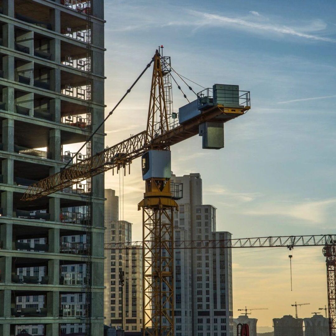 A crane is in the foreground of a building.