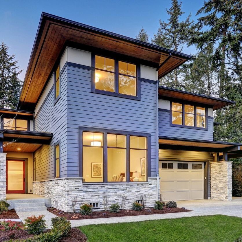 A blue house with a stone driveway and garage.