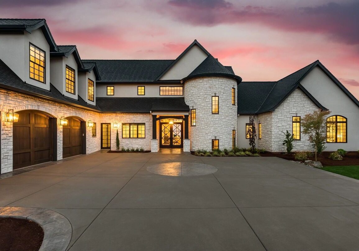 A large white house with a driveway in front of it.