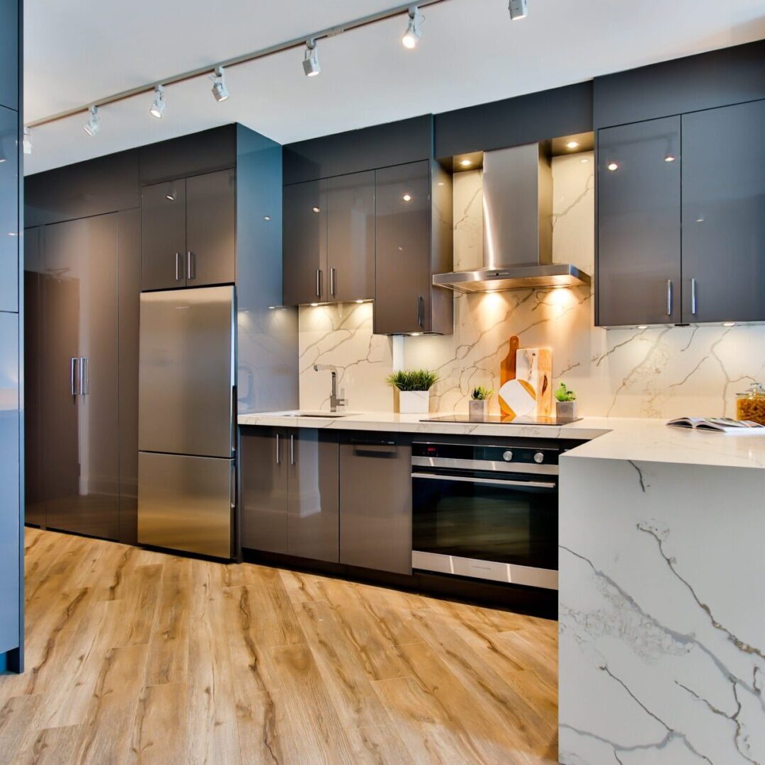 A kitchen with stainless steel appliances and marble counters.